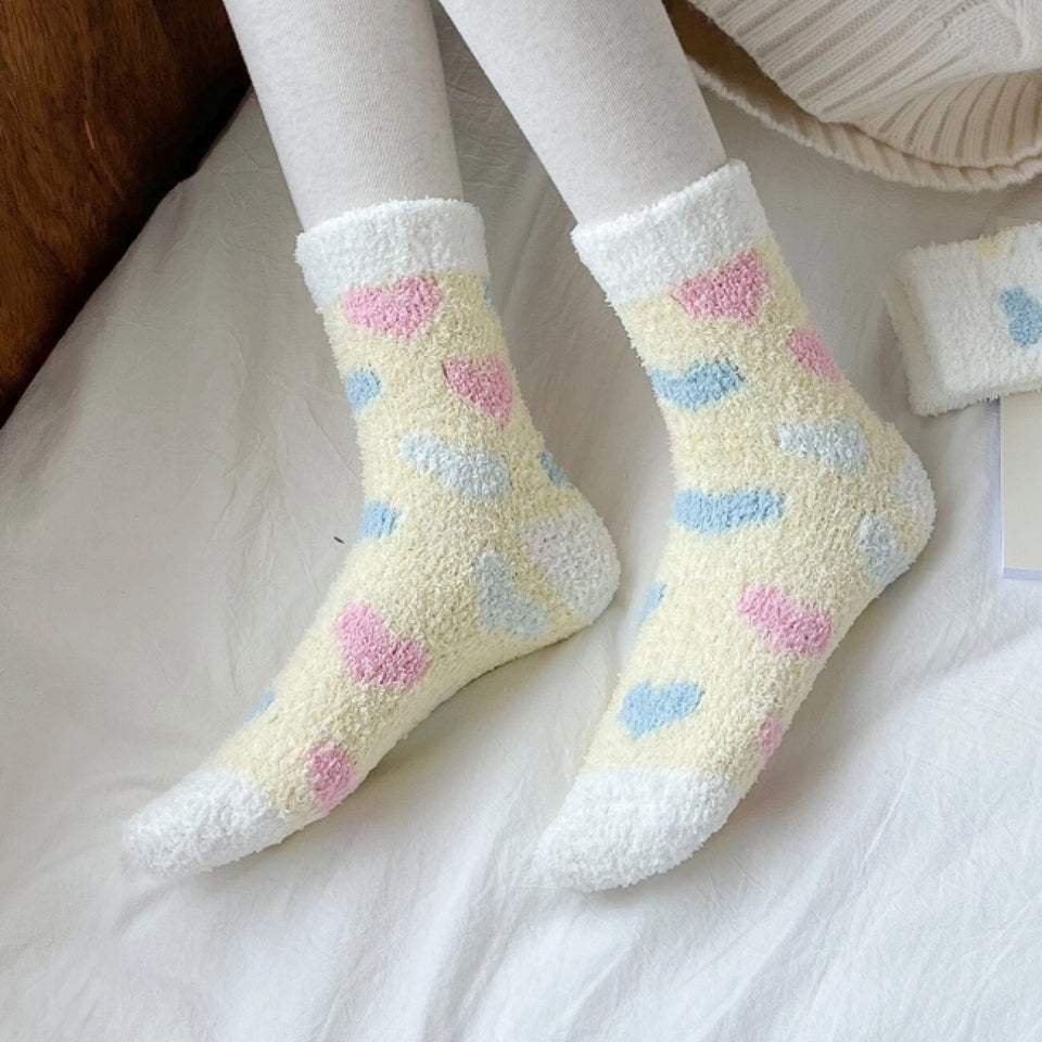 des chaussettes toutes douces et moelleuses en matière pilou réconfortantes au motif de coeurs colorés.