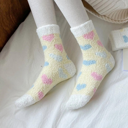 des chaussettes toutes douces et moelleuses en matière pilou réconfortantes au motif de coeurs colorés.
