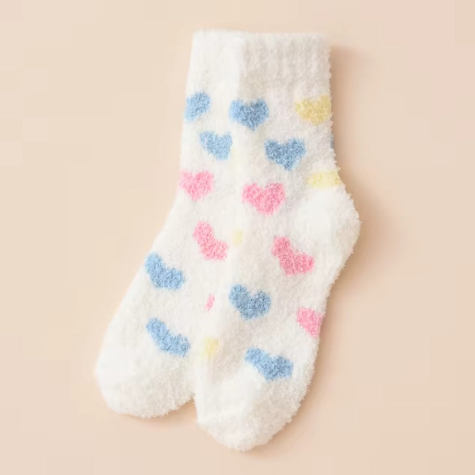 des chaussettes toutes douces et moelleuses en matière pilou réconfortantes au motif de coeurs colorés.