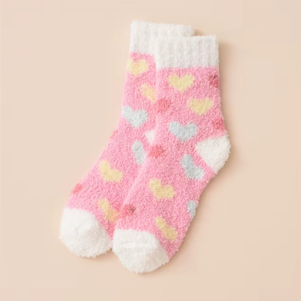 des chaussettes toutes douces et moelleuses en matière pilou réconfortantes au motif de coeurs colorés.