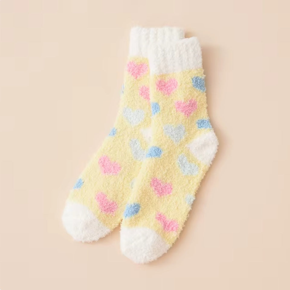 des chaussettes toutes douces et moelleuses en matière pilou réconfortantes au motif de coeurs colorés.