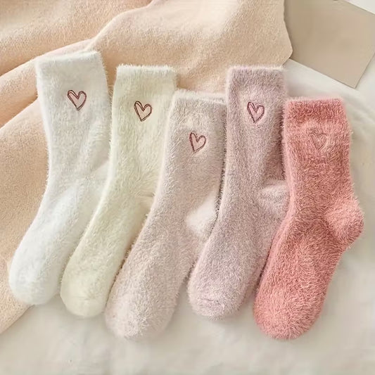 des paires de chaussettes toutes douces en matière pilou dans les tons roses et blancs. Sur le haut de la chaussette, un joli coeur rose est imprimé. Style féminin adorable, idéal pour les soirées cocooning !