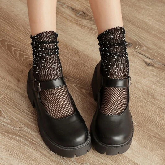 une paire de chaussettes résille noirs ornées de petits strass scintillants