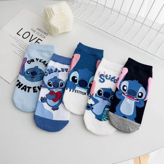 des chaussettes taille unique au design inspiré de Stitch de Lilo et Stitch.Dans les tons bleus, bancs et noirs, ces chaussettes sont toutes douces et on retrouve Stitch dans différentes poses et expressions toutes mignonnes.