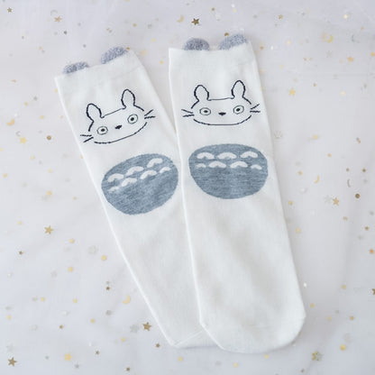 des chaussettes en coton toutes douces et mignonnes inspirées du personnage Totoro du film Mon voisin Totoro. Elles reprennent le design de ce personnage si charismatique et tendre. Retrouvez les chaussettes en coloris blanc, brun, bleu et gris.