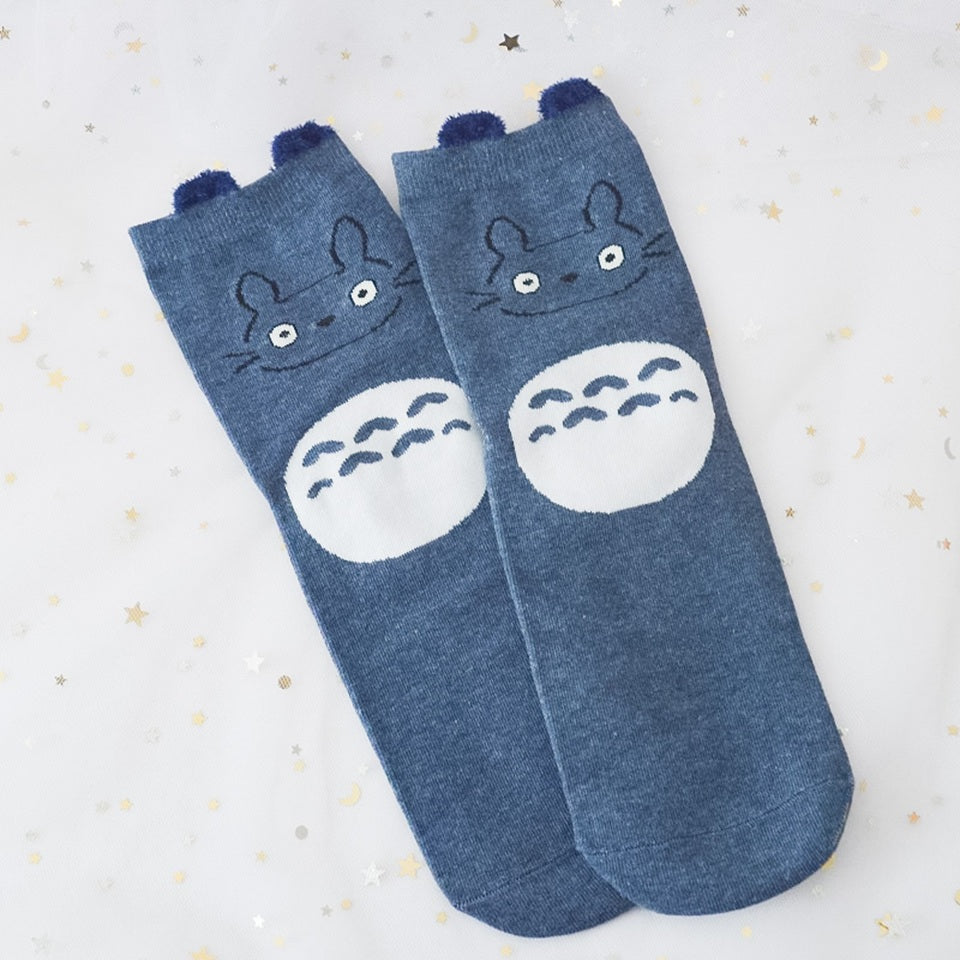 des chaussettes en coton toutes douces et mignonnes inspirées du personnage Totoro du film Mon voisin Totoro. Elles reprennent le design de ce personnage si charismatique et tendre. Retrouvez les chaussettes en coloris blanc, brun, bleu et gris.