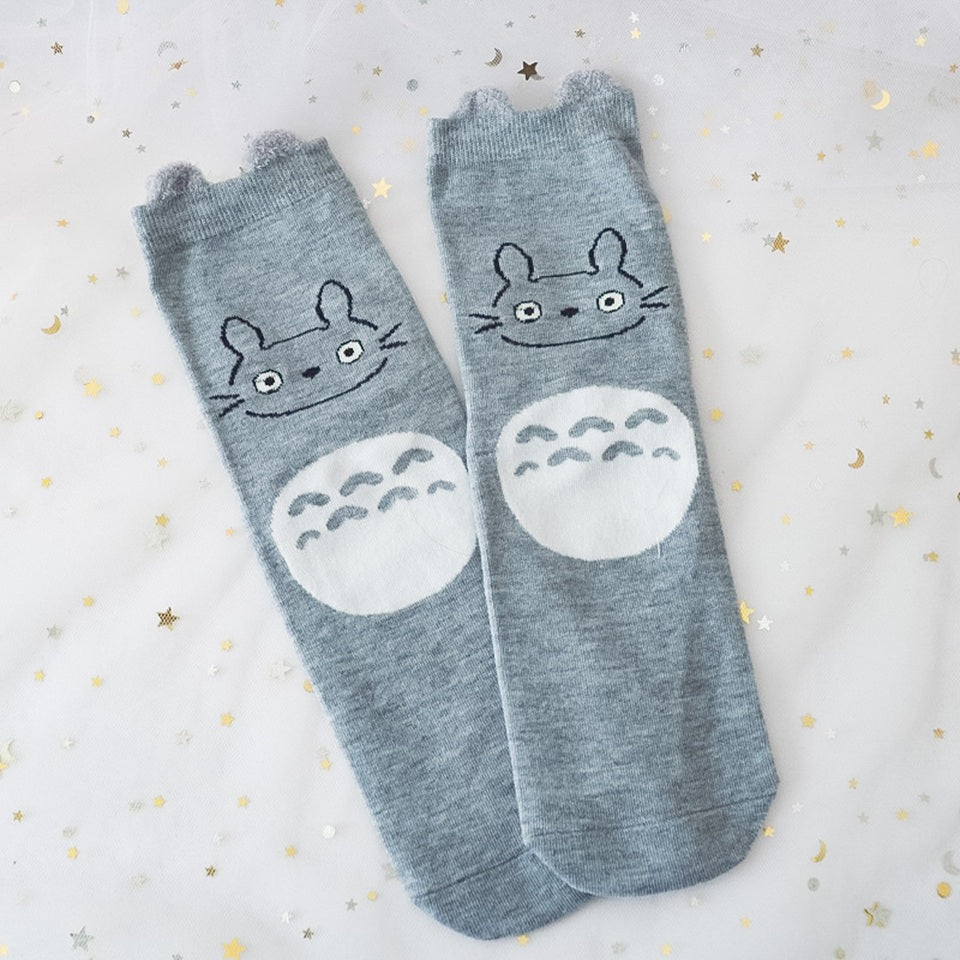 des chaussettes en coton toutes douces et mignonnes inspirées du personnage Totoro du film Mon voisin Totoro. Elles reprennent le design de ce personnage si charismatique et tendre. Retrouvez les chaussettes en coloris blanc, brun, bleu et gris.