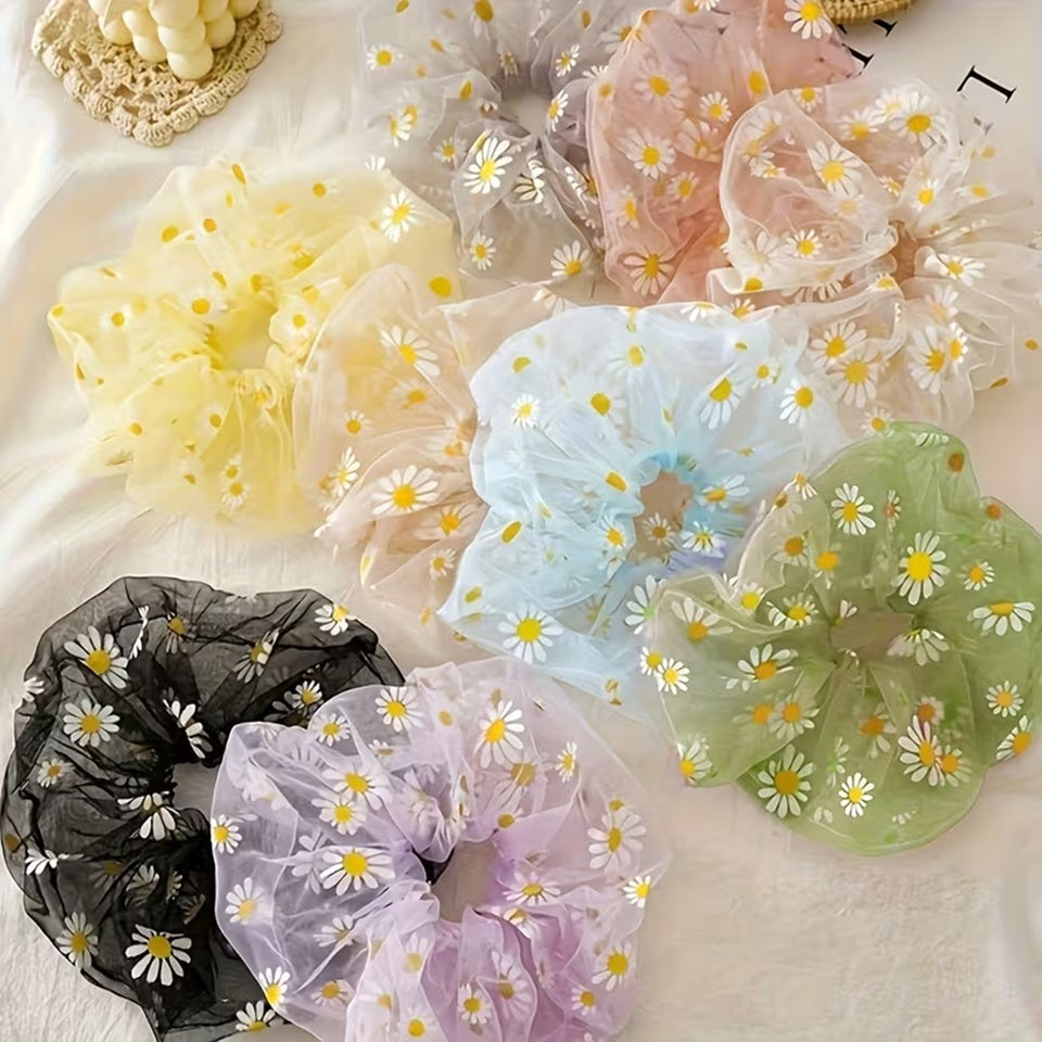 Collection de chouchous en organza à marguerites blanches, déclinés en rose, vert, jaune, bleu, violet et noir, présentés dans une élégante mise en scène calme et douce. Accessoires pour cheveux légers et transparents au style romantique, parfaits pour apporter une touche florale et colorée à toutes les coiffures.