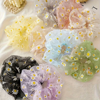 Collection de chouchous en organza à marguerites blanches, déclinés en rose, vert, jaune, bleu, violet et noir, présentés dans une élégante mise en scène calme et douce. Accessoires pour cheveux légers et transparents au style romantique, parfaits pour apporter une touche florale et colorée à toutes les coiffures.
