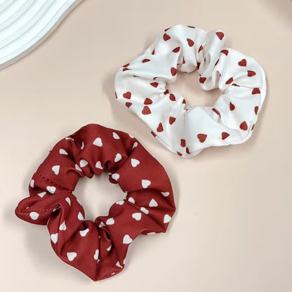 Chouchous cheveux au motif de coeurs rouges et blancs, avec un modèle blanc à coeurs rouges et un modèle bordeaux à coeurs blancs, au style élégant et kawaii.