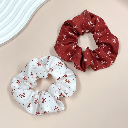 Chouchous cheveux au motif de rubans rouges et blancs, avec un modèle blanc à rubans rouges et un modèle bordeaux à rubans blancs, au style élégant et kawaii.