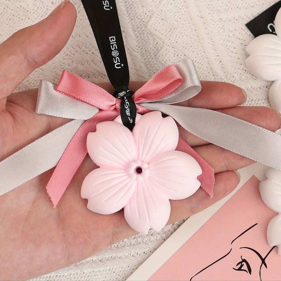 un plâtre décoratif en forme de fleur de sakura rose. Il diffuse une délicate odeur de fleur qui embellit votre pièce ou votre voiture.
