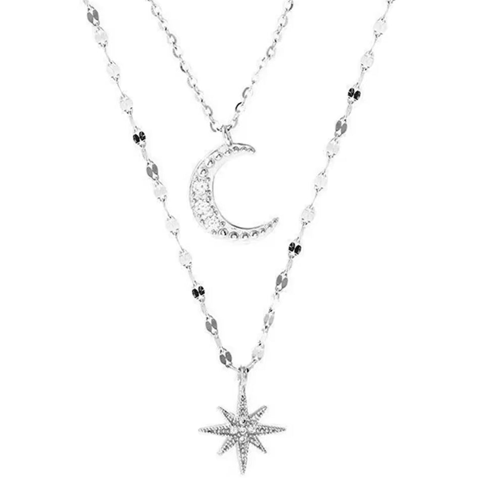 un collier composé de deux chaines argentées et de deux pendentifs tout en strass : une étoile et une lune.