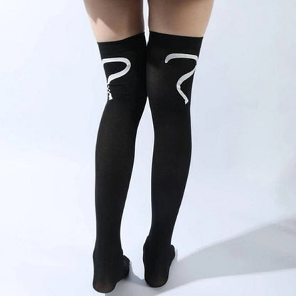 une paire de chaussettes hautes noires au motif d'une tête de chat hyper mignonne à l'avant, et d'une queue à l'arrière. Style unique et adorable.