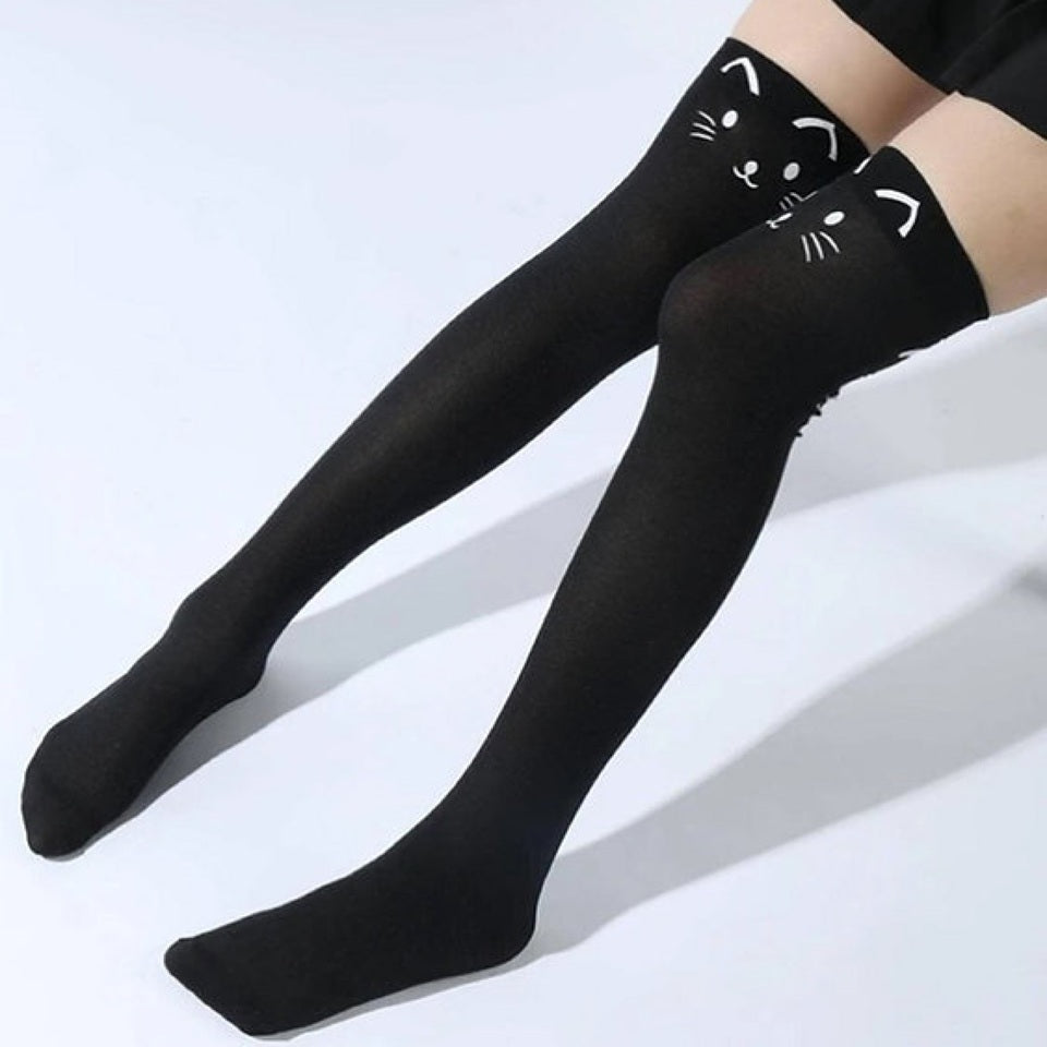 une paire de chaussettes hautes noires au motif d'une tête de chat hyper mignonne à l'avant, et d'une queue à l'arrière. Style unique et adorable.
