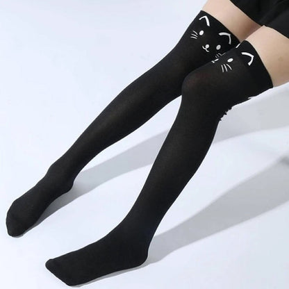une paire de chaussettes hautes noires au motif d'une tête de chat hyper mignonne à l'avant, et d'une queue à l'arrière. Style unique et adorable.