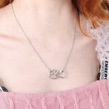 un collier argenté représentant un coeur dans une patte d'animal