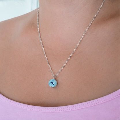 Collier pendentif ciel bleu – vue de profil boule verre avec oiseau noir portée par une femme
