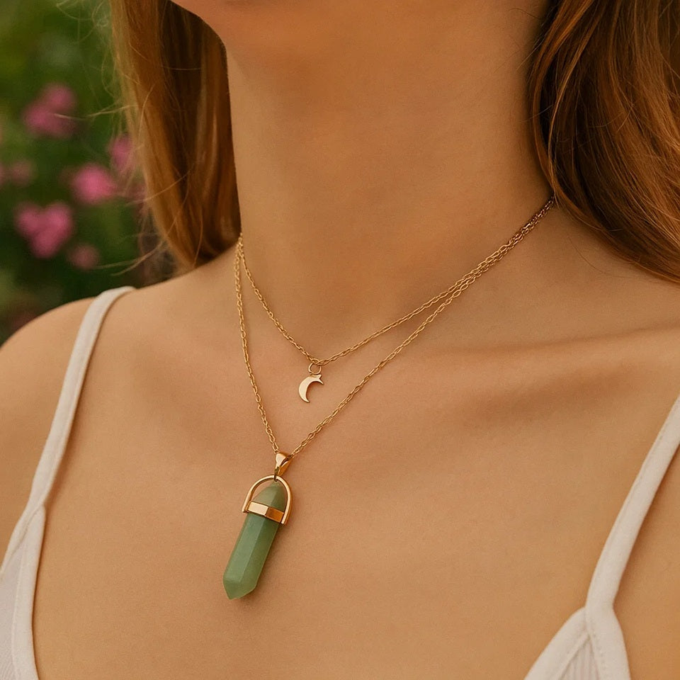 un ras de cou composé de deux chaines corées. Un pendentif en forme de lune dorée et une pierre de jade s'assemblent pour un effet ésotérique charmant.