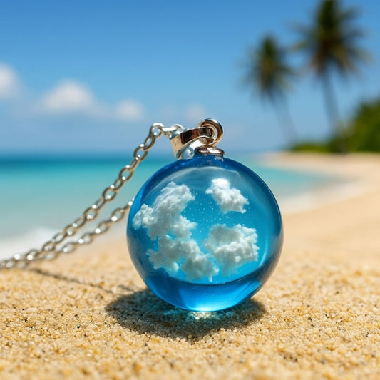 un joli collier argenté d'une sphère transparente et bleue renfermant des nuages comme si un bout d eciel y avait été capturé.