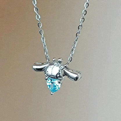 un superbe collier en alliage représentant Cinnamoroll, le petit chien de Sanrio qui tient un strass bleu en forme de coeur dans ses pattes. En coloris argenté, il apporte fraicheur et charme tout en discrétion.