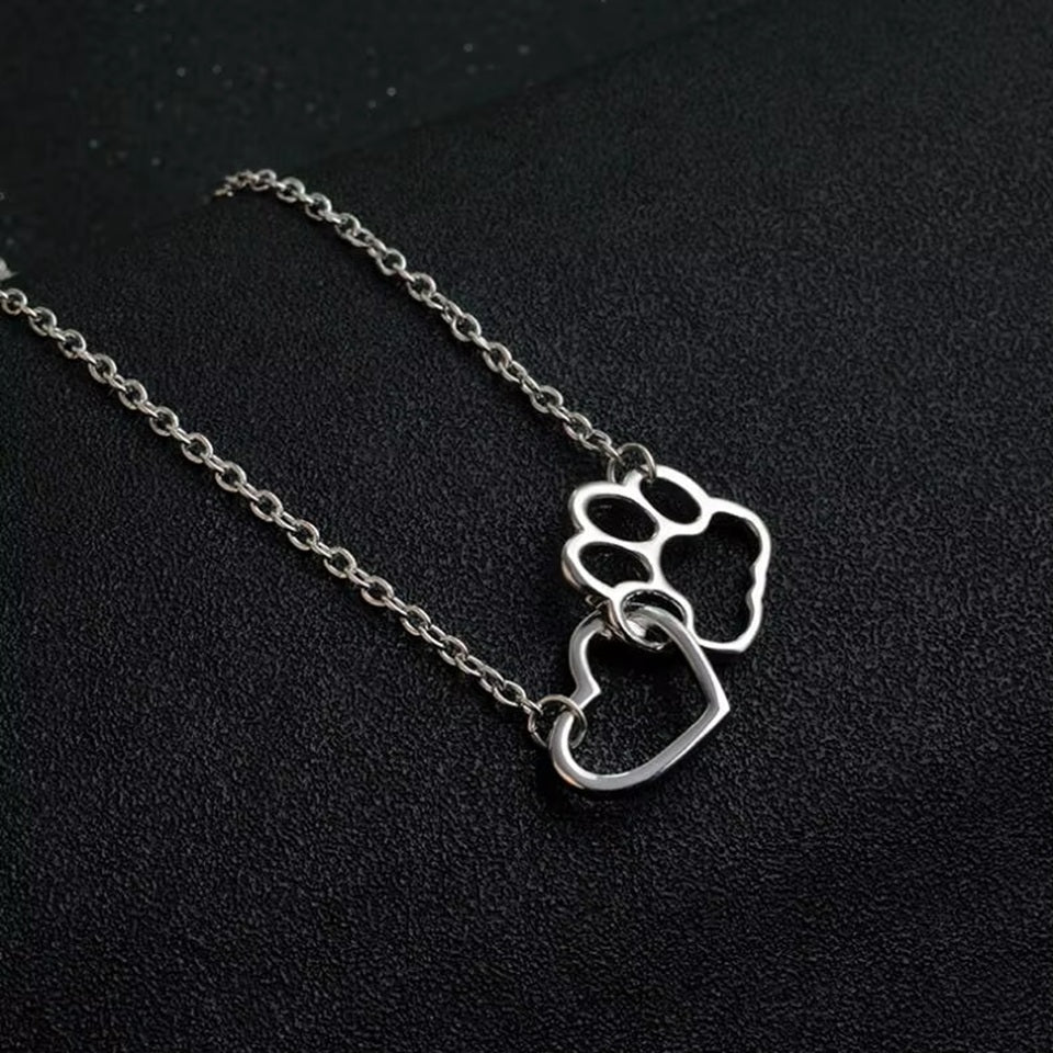un collier argenté représentant un coeur dans une patte d'animal