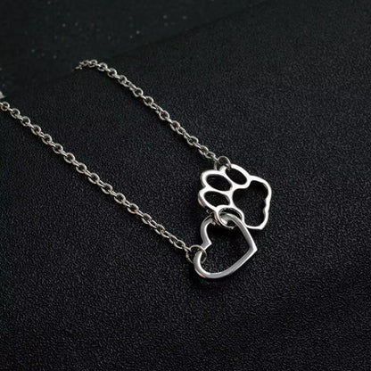 un collier argenté représentant un coeur dans une patte d'animal