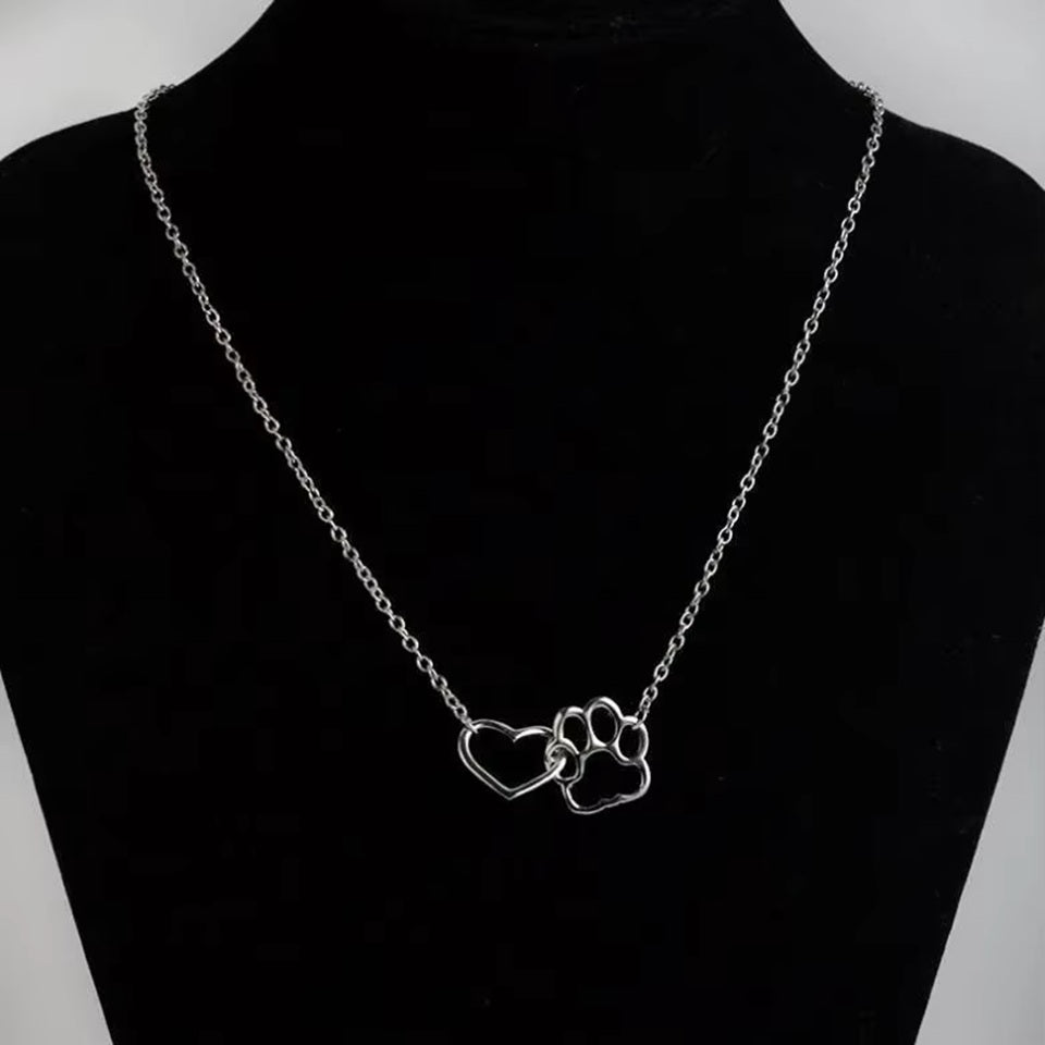 un collier argenté représentant un coeur dans une patte d'animal