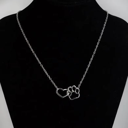 un collier argenté représentant un coeur dans une patte d'animal