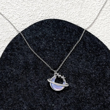 une collier argenté en forme d'une lune majestueuse aux reflets bleutés, un anneau scintillant l'entoure.