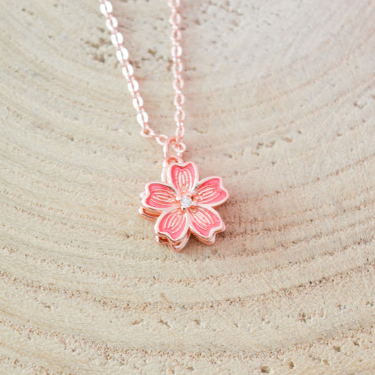 un collier dont le pendentif représente une jolie fleur de sakura rose que l'on peut faire tourner. Son effet rotatif permet de s'apaiser et a un effet anti stress