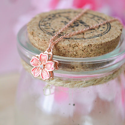 un collier dont le pendentif représente une jolie fleur de sakura rose que l'on peut faire tourner. Son effet rotatif permet de s'apaiser et a un effet anti stress