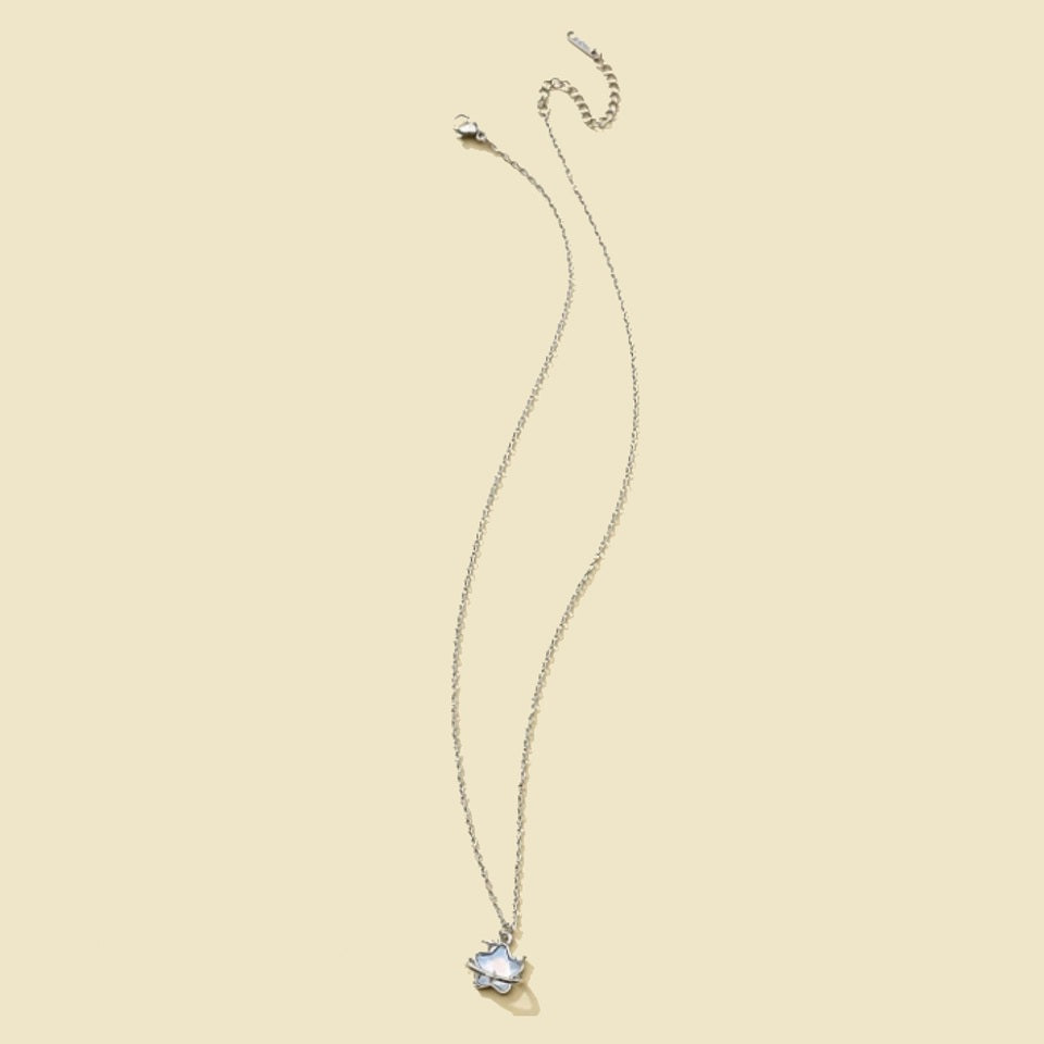 une collier unique et original en coloris argenté, d'une étoile aux reflets bleutés, entouré d'un anneau étoilé. 