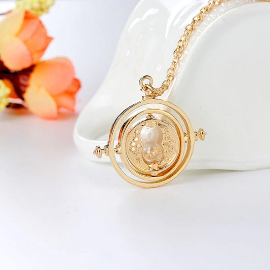 un collier doré reprenant la forme et le design du fameux retourneur de temps, le collier d'Hermione dans Harry Potter. Il y a un sabler, des anneaux rotatifs.