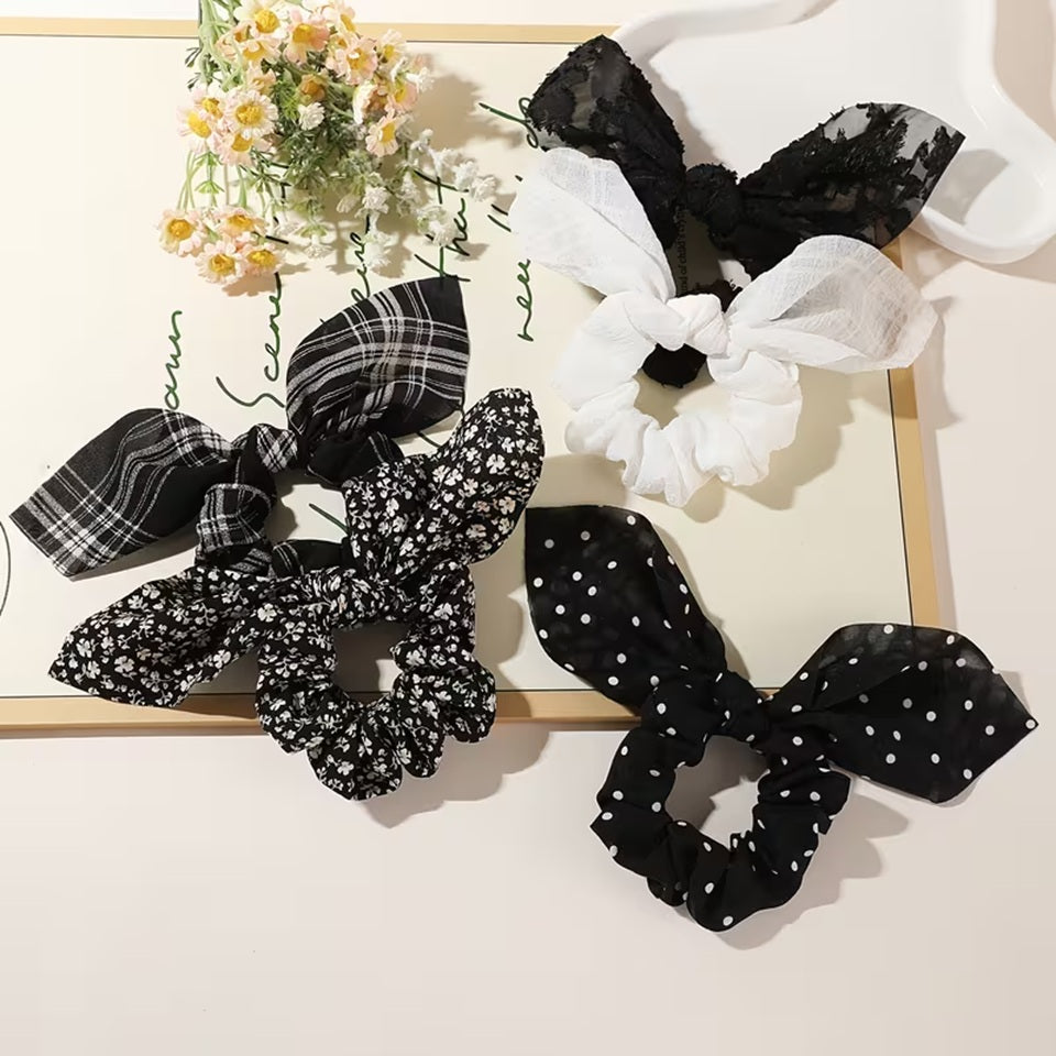 Ensemble de chouchou blancs et noirs avec différents motifs variés : lignes, fleurs, pois, brodés ou gaufrés. Ils sont adorables et ajoutent une touche d'élégance à n'importe quelle coiffure.