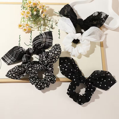 Ensemble de chouchou blancs et noirs avec différents motifs variés : lignes, fleurs, pois, brodés ou gaufrés. Ils sont adorables et ajoutent une touche d'élégance à n'importe quelle coiffure.