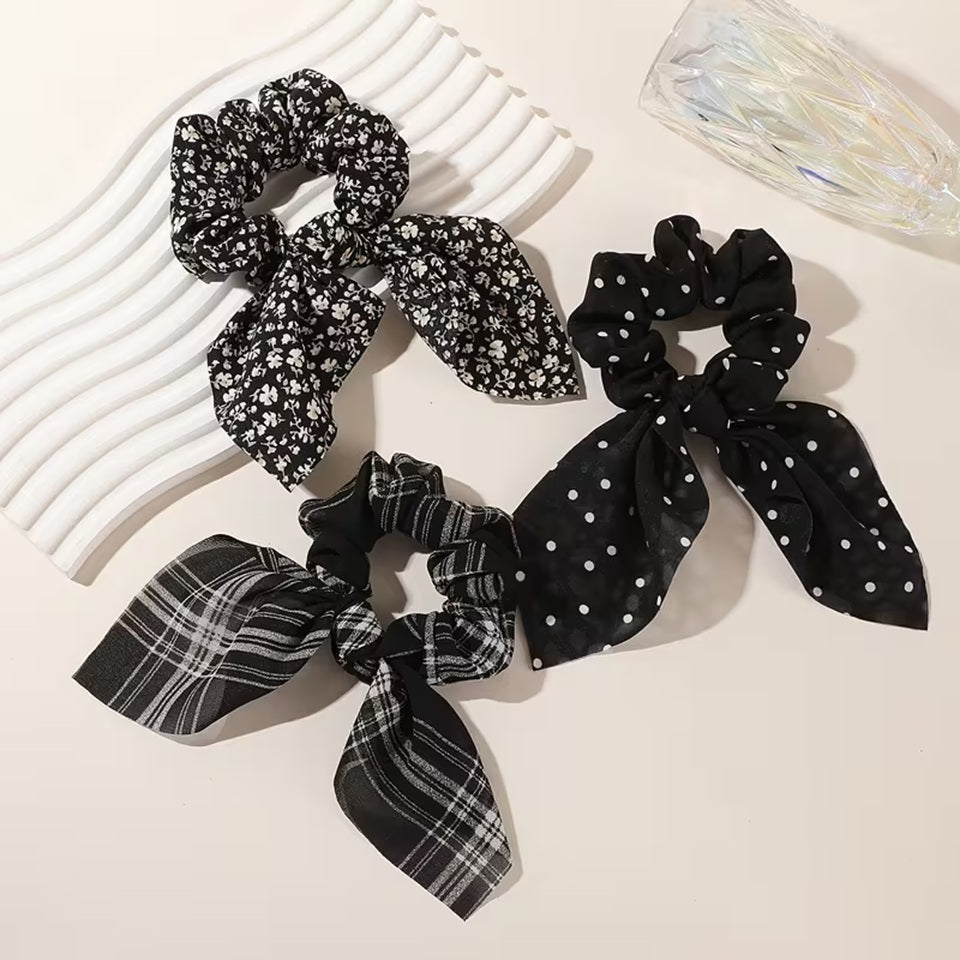 Ensemble de trois chouchous blancs et noirs avec différents motifs variés : lignes, fleurs et pois. Ils sont adorables et ajoutent une touche d'élégance à n'importe quelle coiffure.