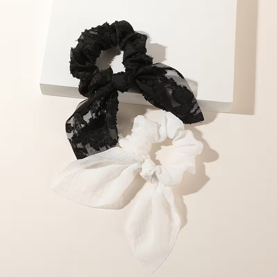 Ensemble de deux chouchous blancs et noirs brodés et gaufrés. Ils sont adorables et ajoutent une touche d'élégance à n'importe quelle coiffure.