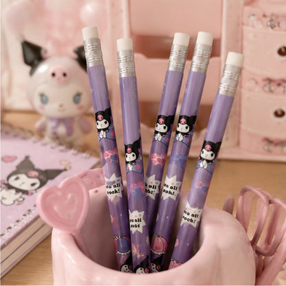Quatre crayons à papier violets décorés de Kuromi sont rangés dans un pot à crayons rose en forme de tasse. L'ensemble est posé sur un bureau kawaii avec un carnet illustré, une petite figurine, des accessoires roses et un fond pastel créant une ambiance douce et chaleureuse