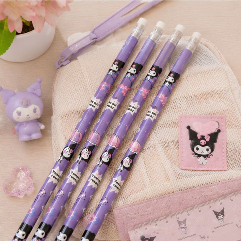 Quatre crayons à papier Kuromi reposent sur un bureau en bois à côté de figurines kawaii. L'éclairage chaleureux crée une atmosphère cosy idéale pour l'écriture ou les études