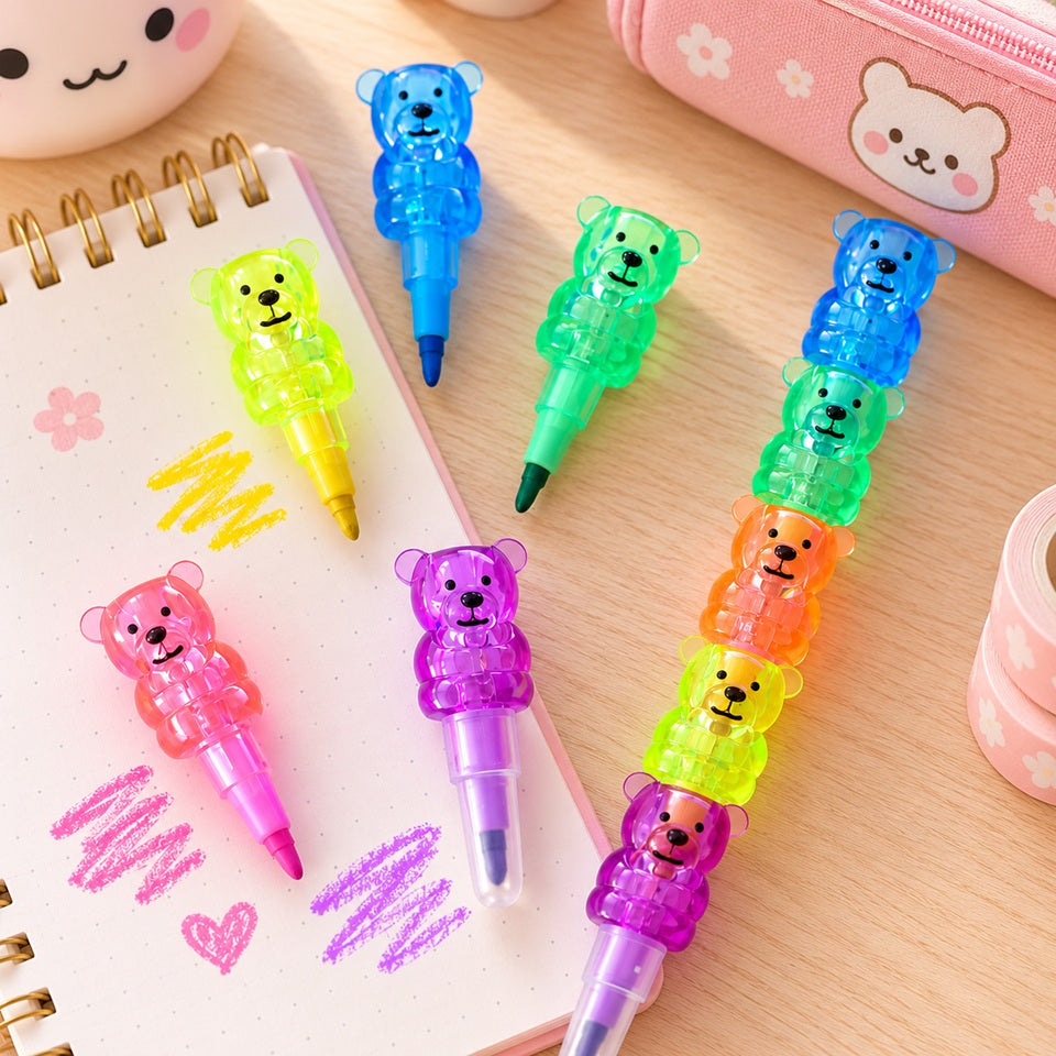 Crayons de couleur kawaii en forme d'oursons translucides empilables, aux couleurs vives rose, bleu, vert, jaune, orange et violet. Présentés sur un bureau en bois clair avec un carnet de coloriage et une trousse rose décorée d'un ourson, ces crayons originaux et amusants s'emboîtent les uns sur les autres pour un gain de place. Papeterie kawaii adorable, idéale pour dessiner, colorier et décorer son bureau.