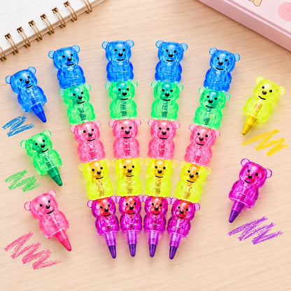 Crayons de couleur kawaii en forme d'oursons empilables, aux couleurs vives bleu, vert, orange, jaune et violet. Présentés à plat sur un bureau en bois clair, ces adorables crayons translucides s'emboîtent les uns sur les autres pour un rangement pratique et un gain de place. Papeterie originale, colorée et amusante, idéale pour le dessin, le coloriage et les amoureux des accessoires kawaii.