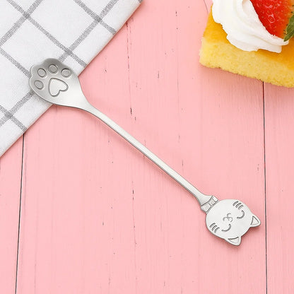 une adorable cuillère en acier inoxydable en forme de patte de chat. Au bout du manche se trouve une tête de chat toute mignonne.