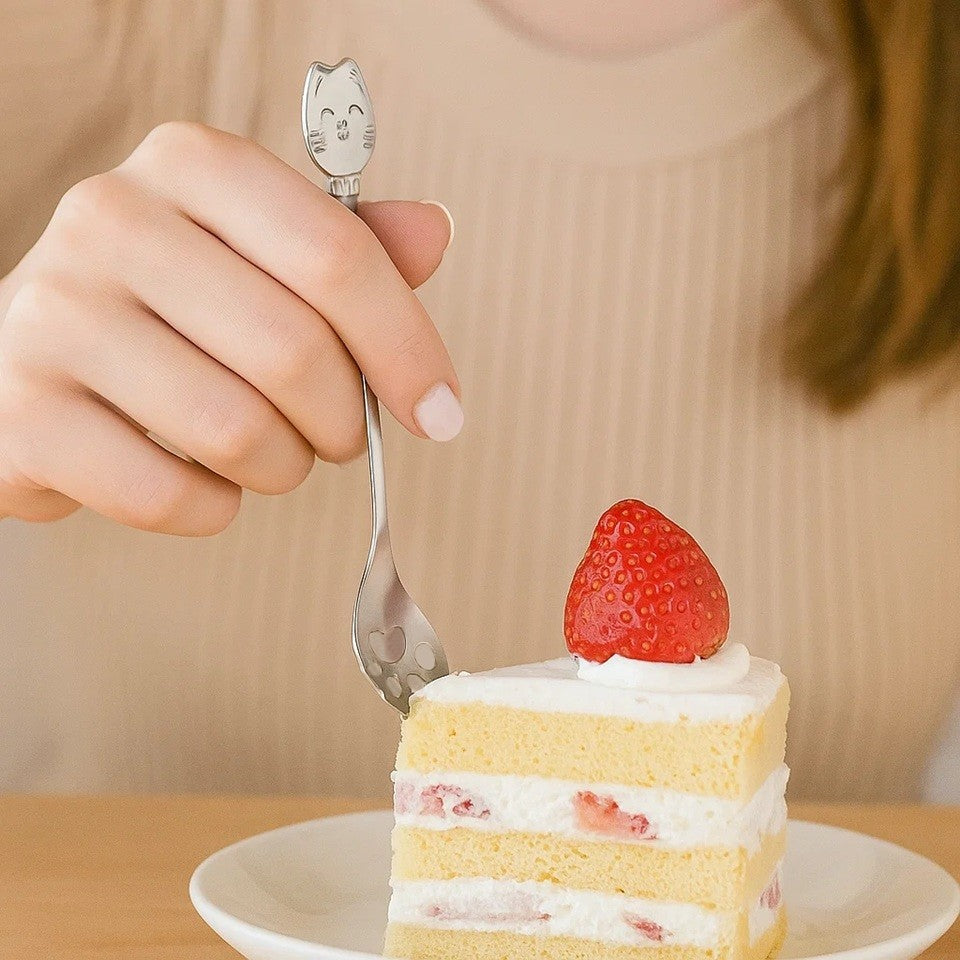 une adorable cuillère en acier inoxydable en forme de patte de chat. Au bout du manche se trouve une tête de chat toute mignonne.