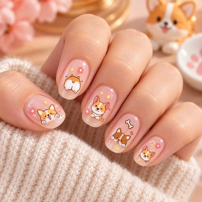 Manucure kawaii avec stickers nail art Corgi, petites pattes, os et fesses de chien, posés sur des ongles rose nude.