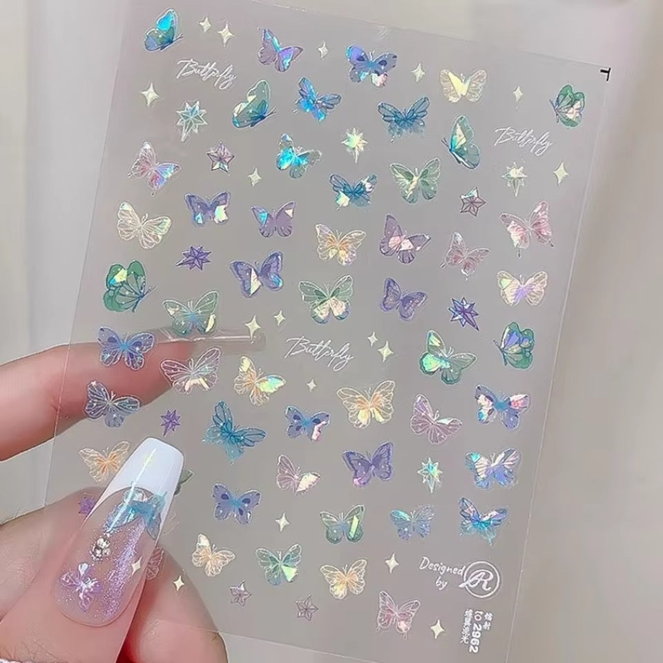 des stickers pour le nail art en forme de papillons colorés et irisés. Facile et pratique à utiliser, il suffit de les décoller de leur support et de les coller sur les ongles.