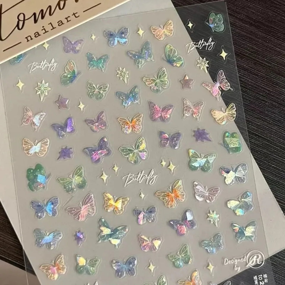 des stickers pour le nail art en forme de papillons colorés et irisés. Facile et pratique à utiliser, il suffit de les décoller de leur support et de les coller sur les ongles.