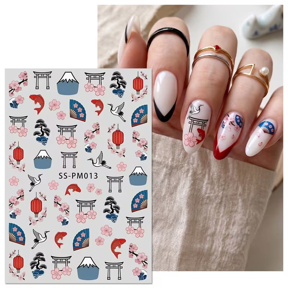 une planche de sticker pour nail art sur le thème du japon : sakura, tori, éventails, carpe koi et mont fuji présentés posés sur des ongles vernis. Ils sont colorés et rappellent Le japon et son folklore.