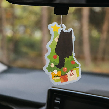 un désodorisant à suspendre en forme d'un adorable et espiègle chat noir qui grimpe dans un sapin de Noël. Hyper amusant, il sent l'orange épicée, odeur typique de la saison hivernale
