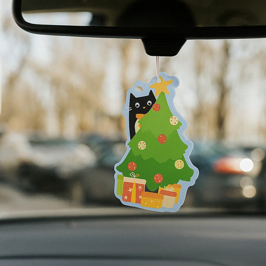 un désodorisant à suspendre en forme d'un adorable et espiègle chat noir qui grimpe dans un sapin de Noël. Hyper amusant, il sent l'orange épicée, odeur typique de la saison hivernale